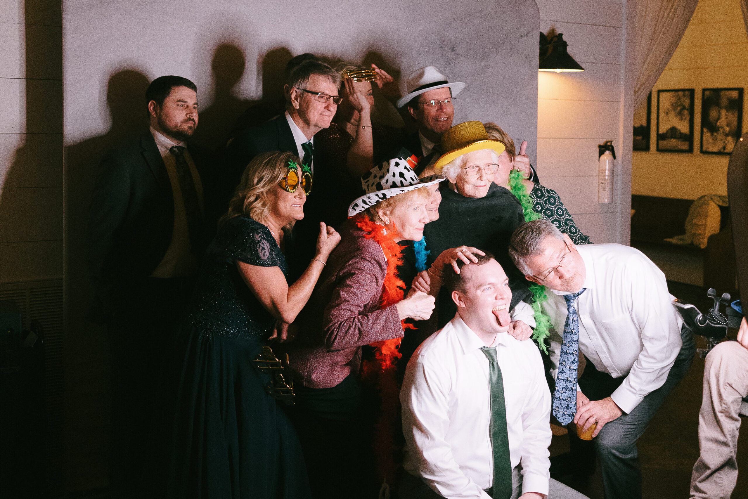 Family and friends dressed in costume smiling and making faces at a photobooth camera.