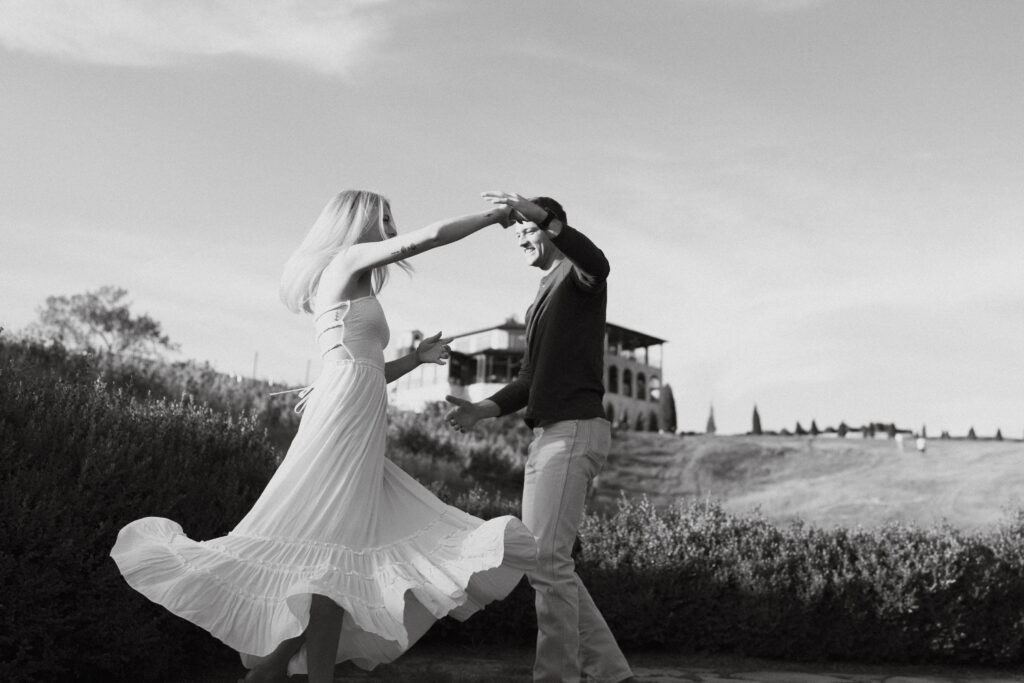 Couple holding hands and dancing in a field at Montaluce Vineyard and Winery