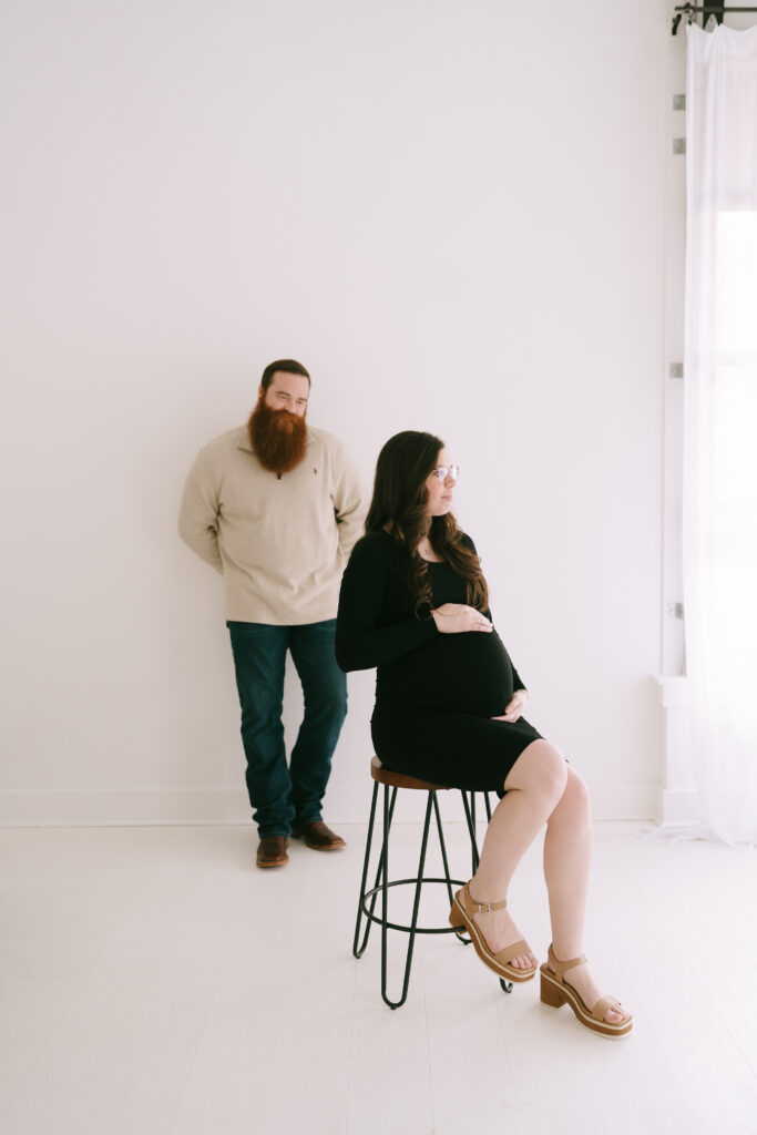 Man standing and gazing at seated woman in a white washed studio