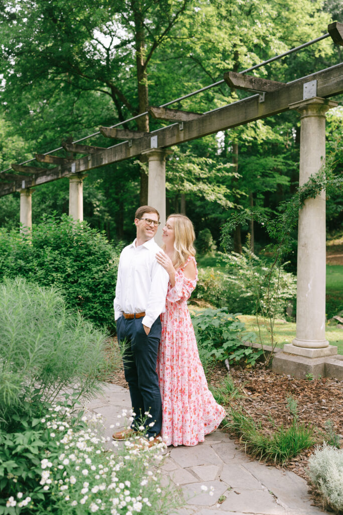 Couple standing in front of stone structure gazing at one another in Catorwoolford Gardens