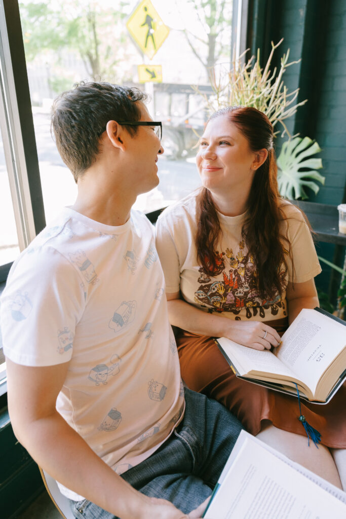 Couple sitting and gazing at each other with open books in their hands