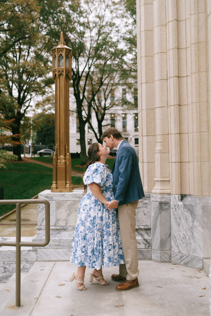 Couple holding hands and kissing on the Georgia Courthouse stairs