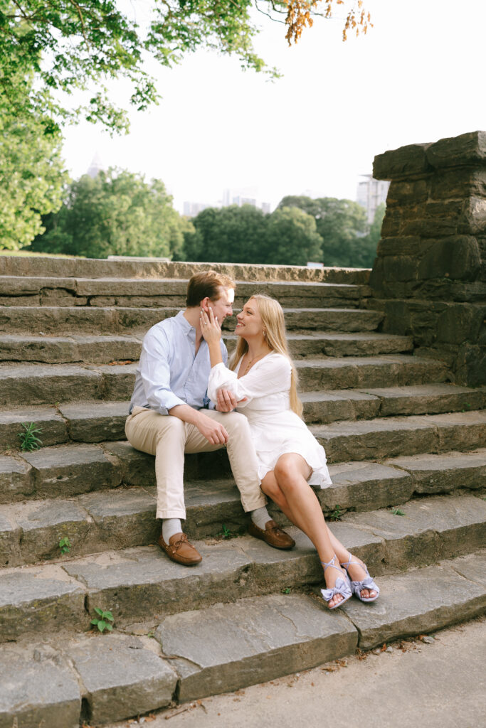 Couple sitting on stone steps gazing at each other in Piedmont Park