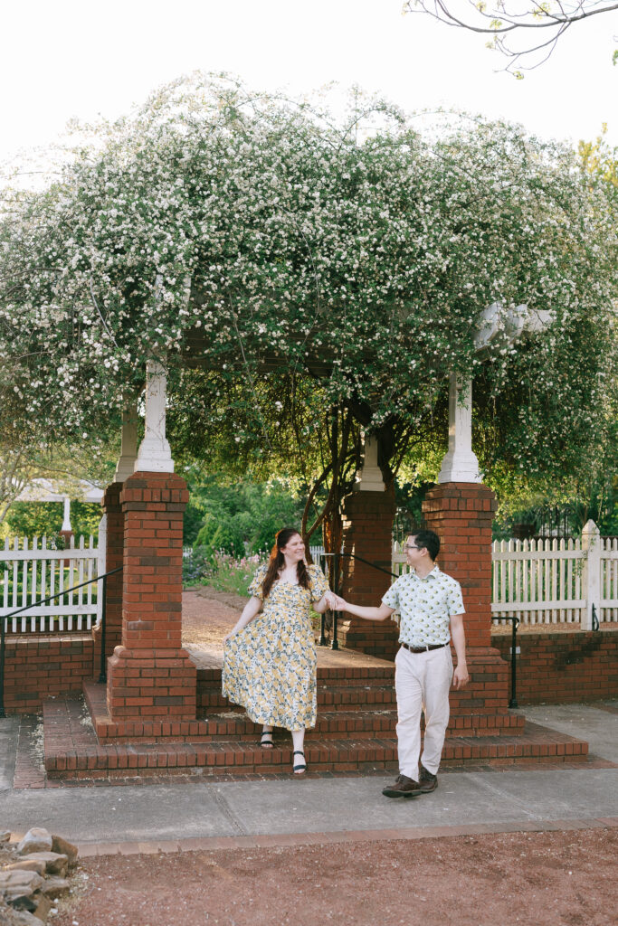 Couple walking down an arched brick stairway gazing at one another