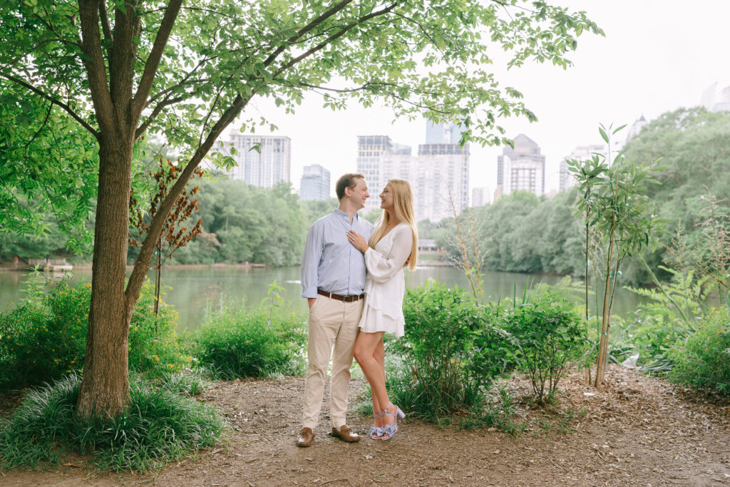 Couple standing and gazing at each other in a wooded area in Piedmont Park