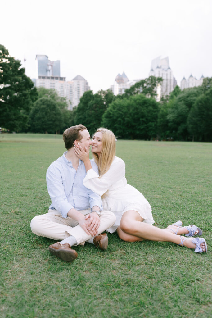 Couple sitting beside each other on a grass field in Piedmont Park