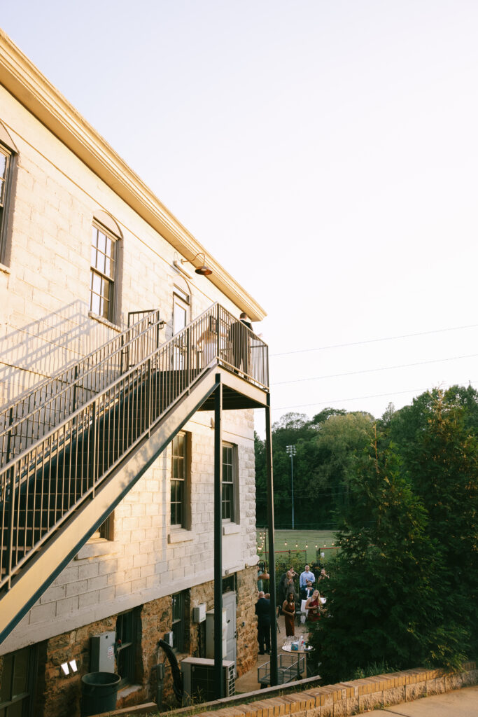 Sunlight creates a golden color on a white building with a metal staircase.