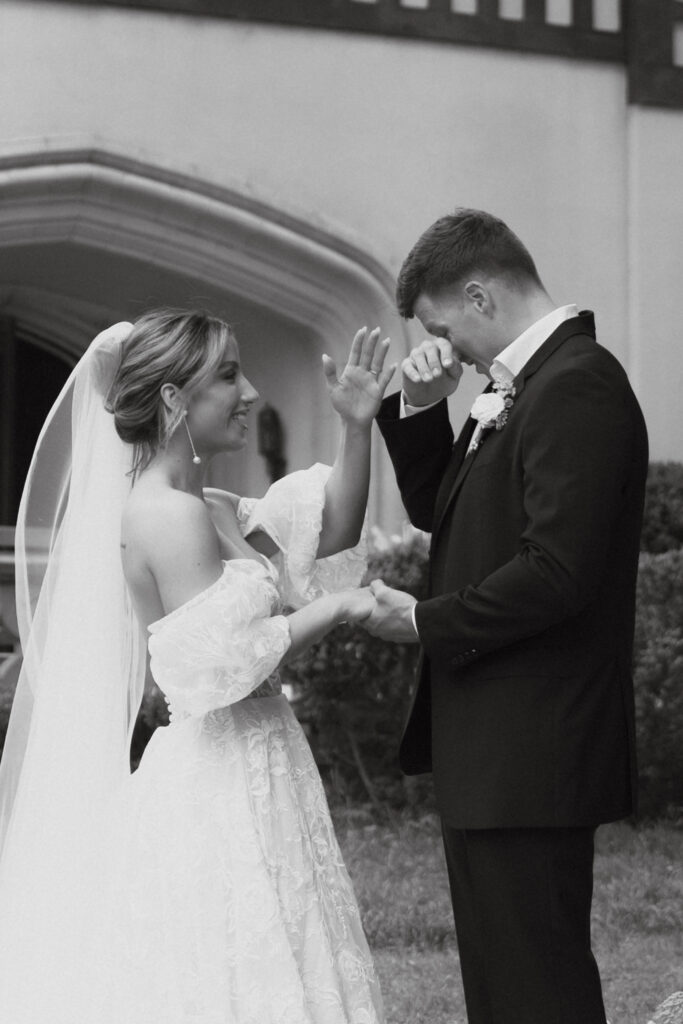 Groom wiping away tears as he holds bride's hand