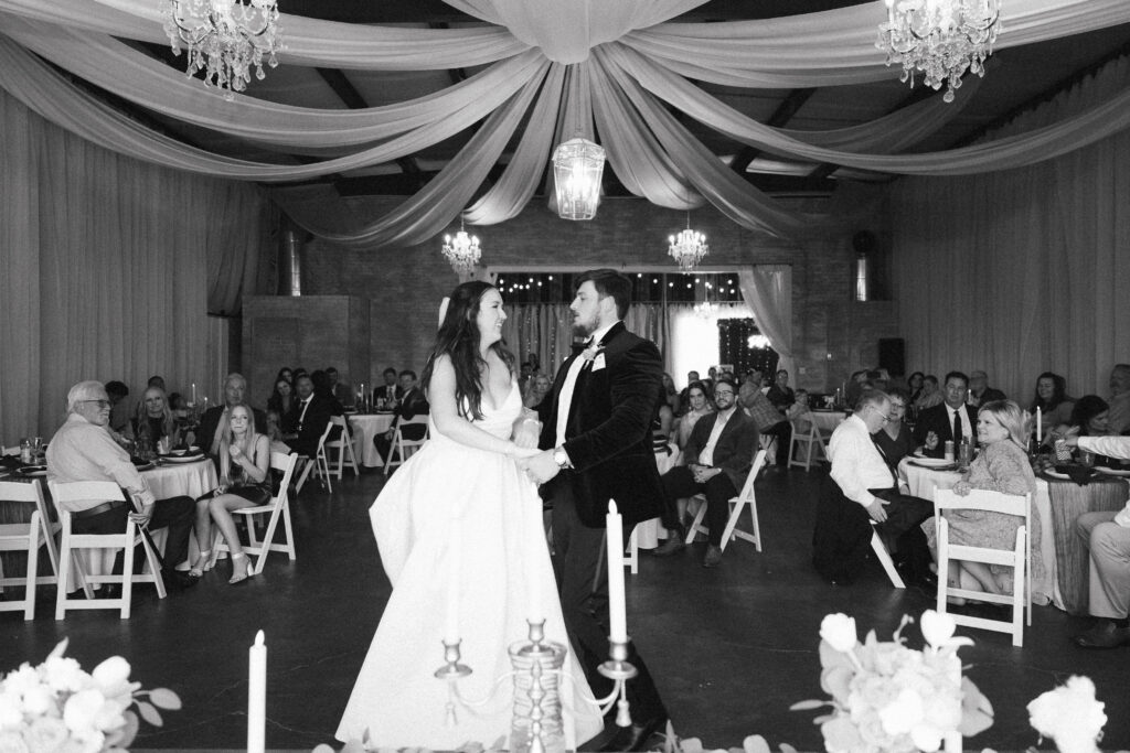 In black and white of bride and groom dancing.