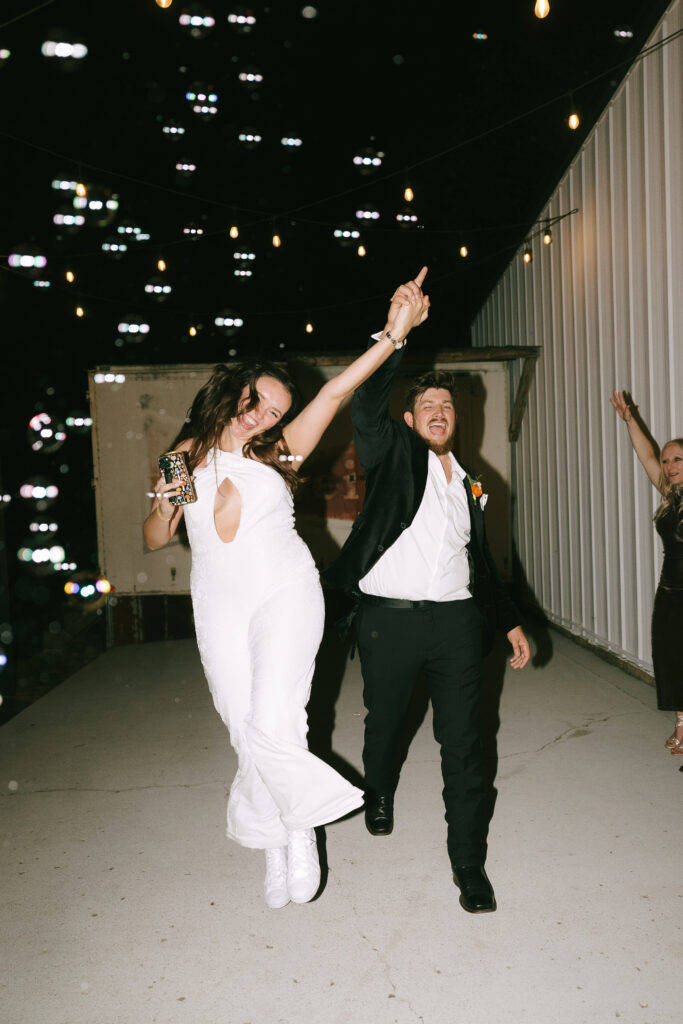 Bride skipping down walkway exit with groom.