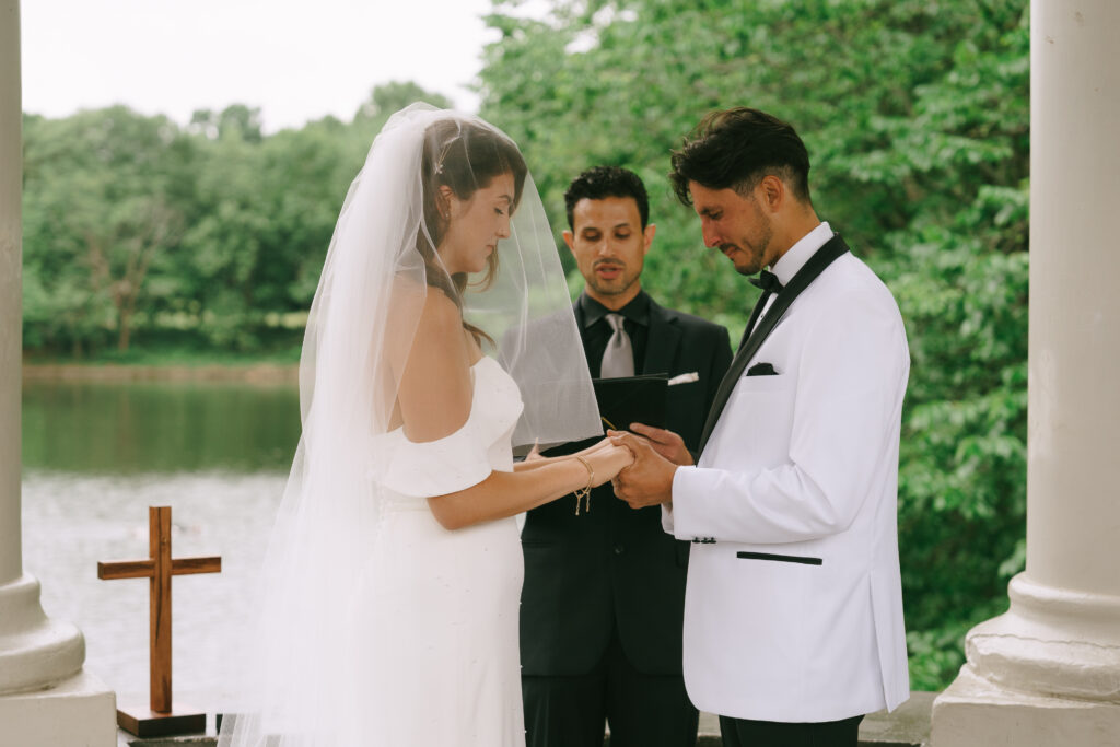 Bride and groom with hands clasped together in prayer.