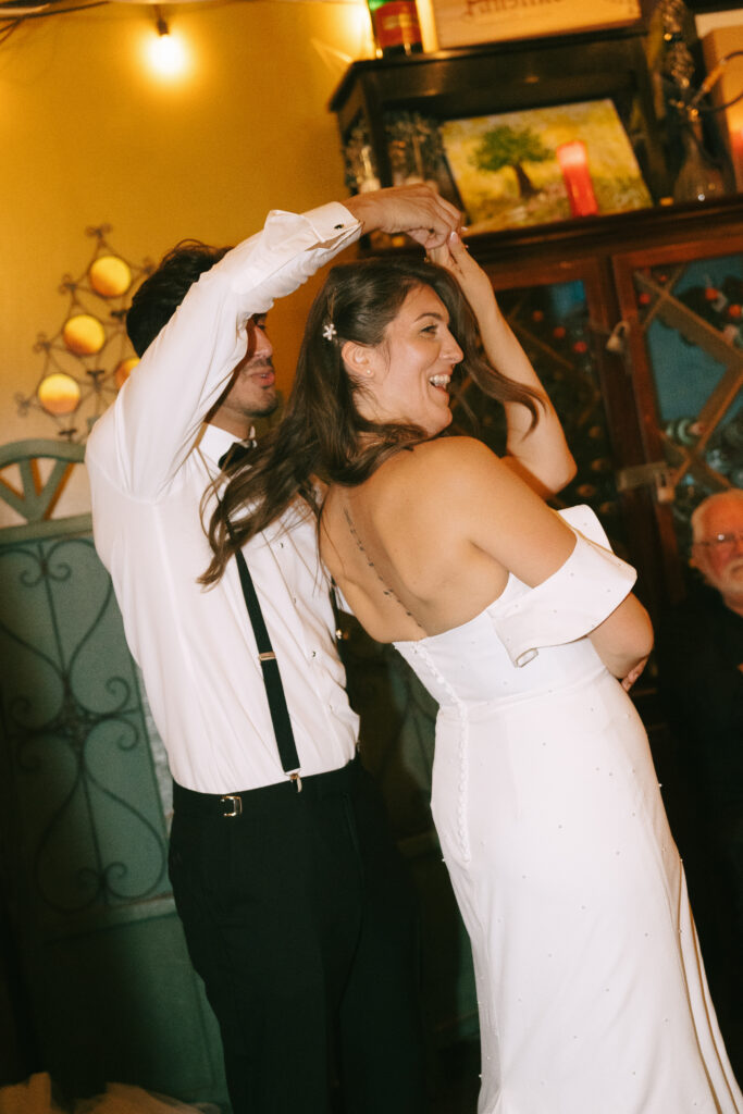 Groom dancing and spinning bride at wedding reception.