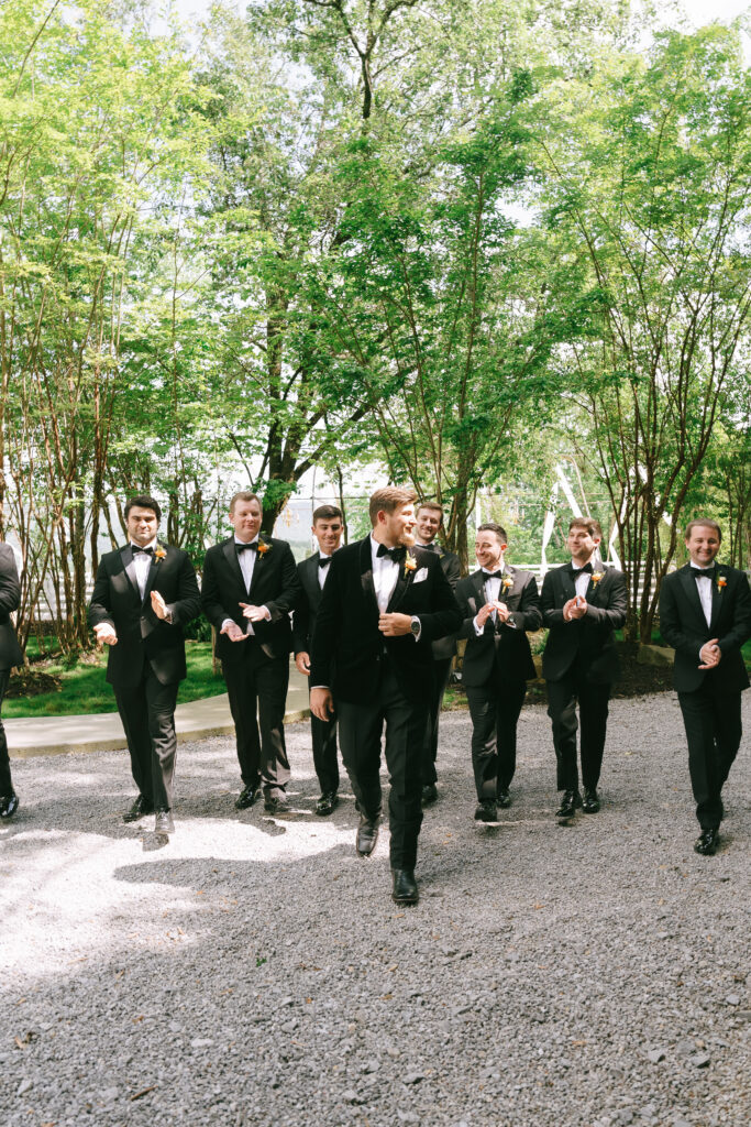 Groom and groomsmen walking and talking.