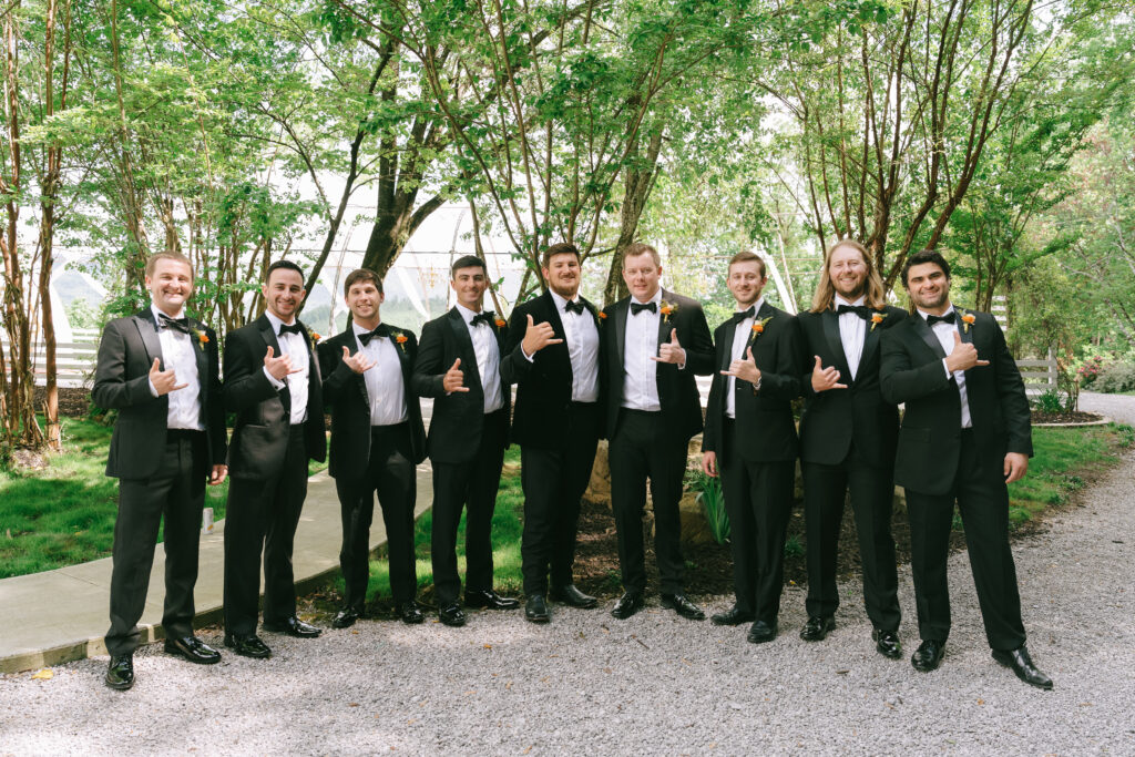 Groom and groomsmen standing in a line in tuxedos. 