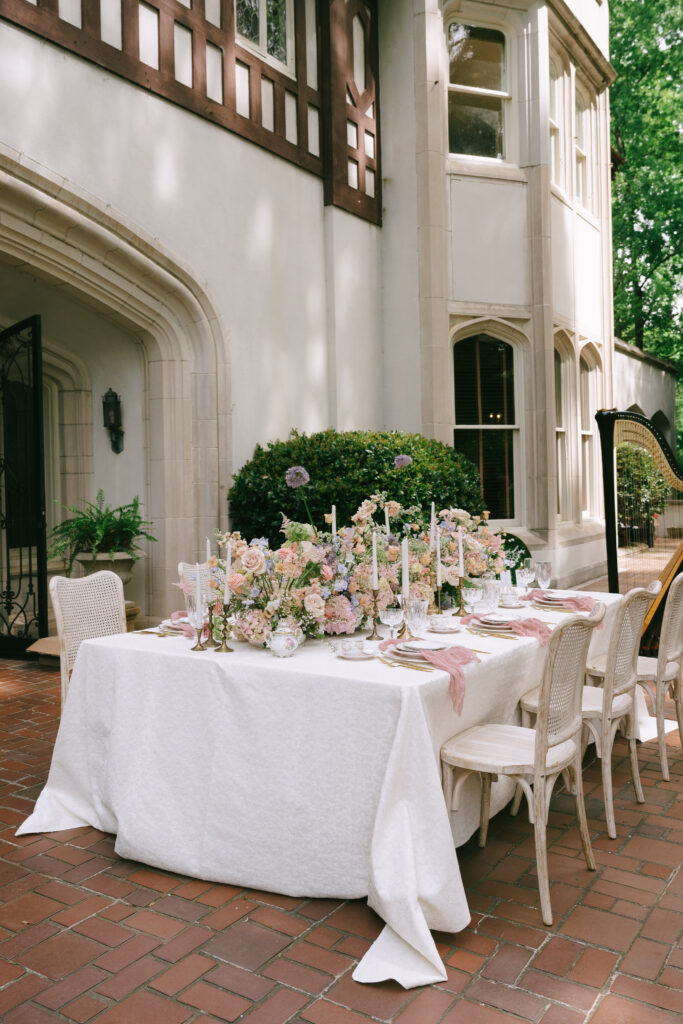 Banquet table filled with floral centerpieces in front of Callanwolde Fine Arts Center