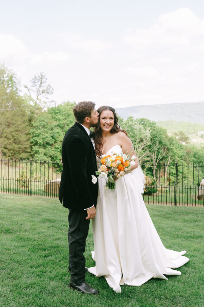 Bride and groom posed at The Venue at the Bluffs with mountains in the background