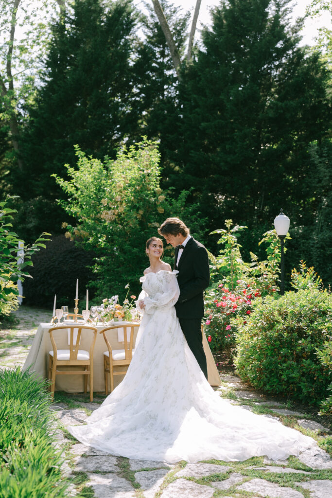 Bride and Groom embracing and smiling in the lush gardens at Wildflower 301.