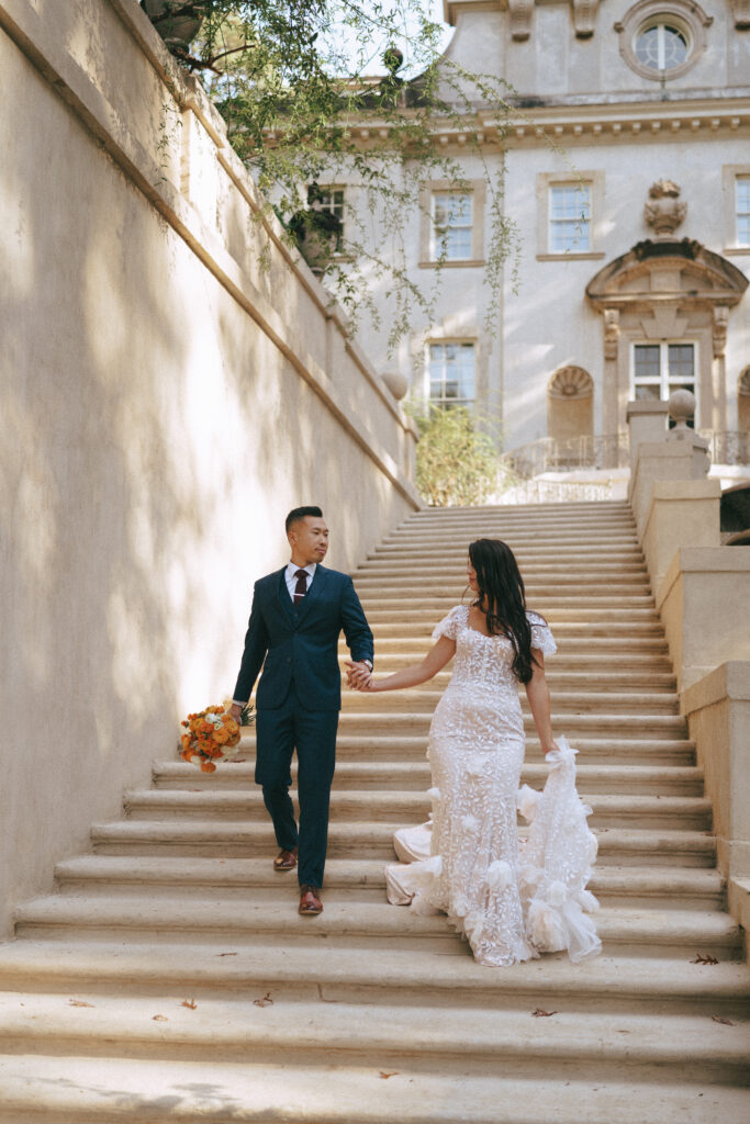 Bride and groom walking down stone staircase at The Swan House